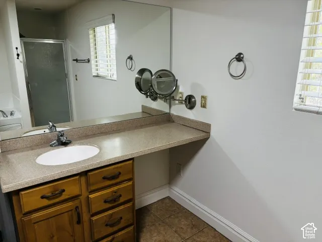 Built-in vanity with wood-finish cabinetry, integrated sink, and extended countertop