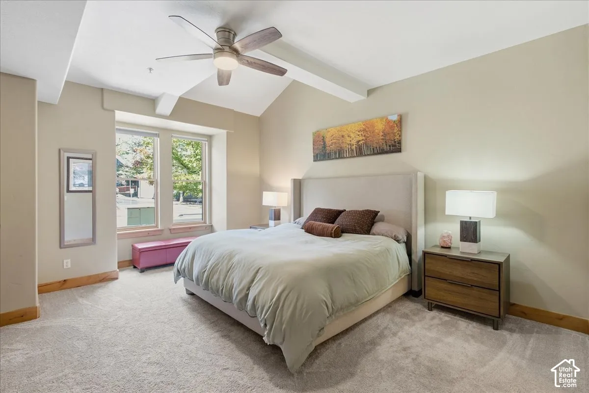 Vaulted ceiling with exposed beam, ceiling fan, and recessed lighting