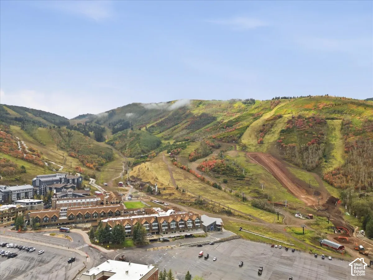 Mountainous terrain with natural landscaping, visible ski runs, and multiple structures