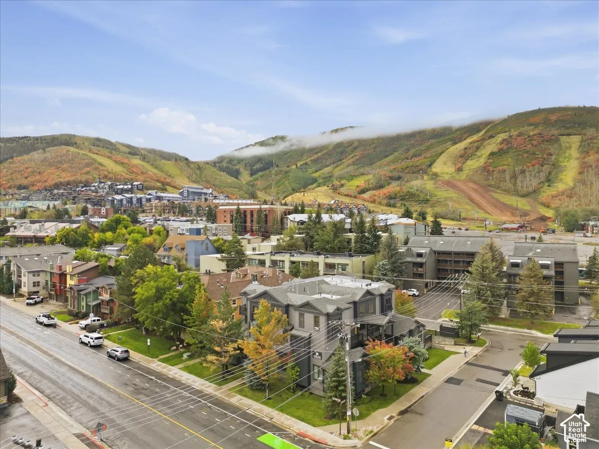 Aerial perspective showcasing mountainous terrain, surrounding buildings, and paved roads
