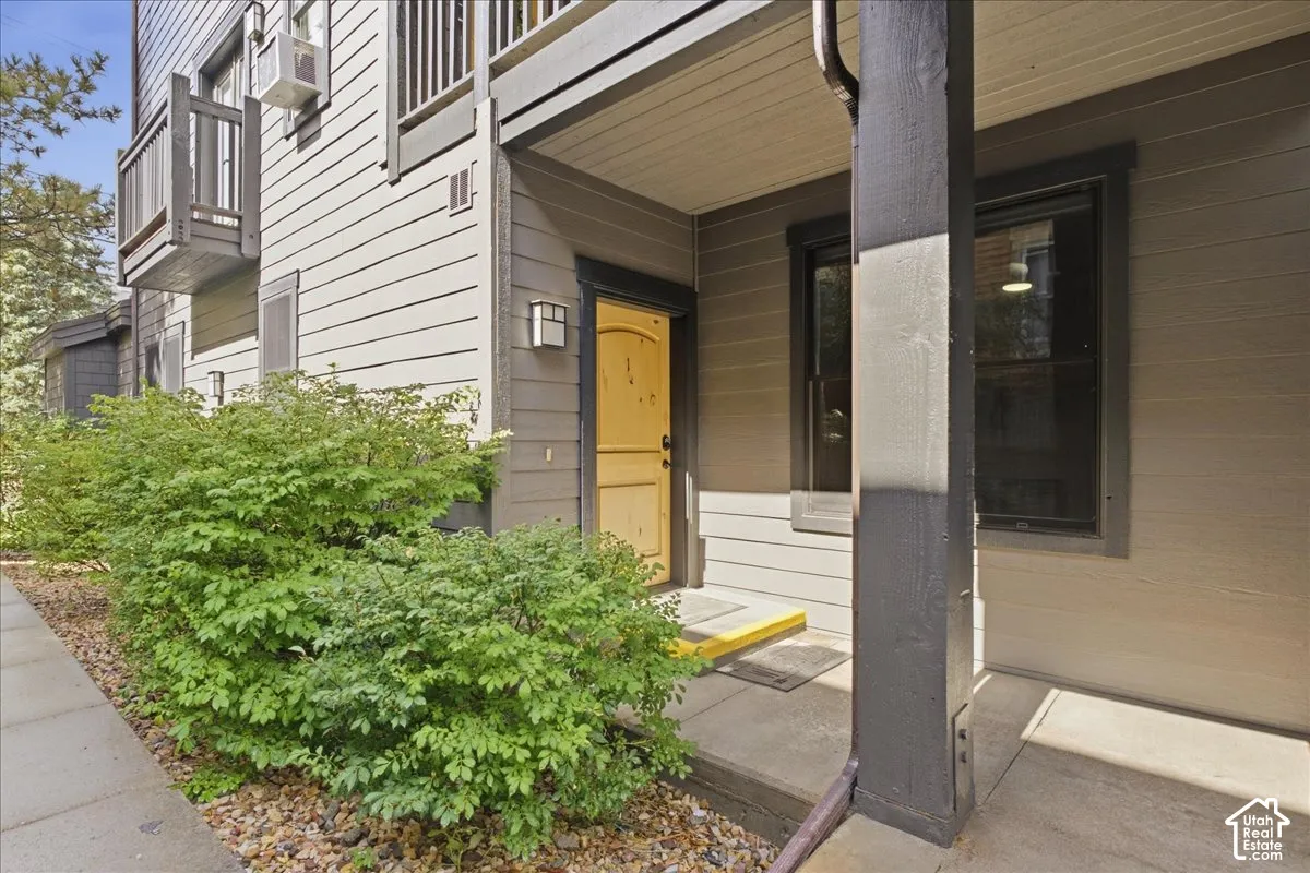 Covered entryway with concrete flooring, accented by a bright yellow door