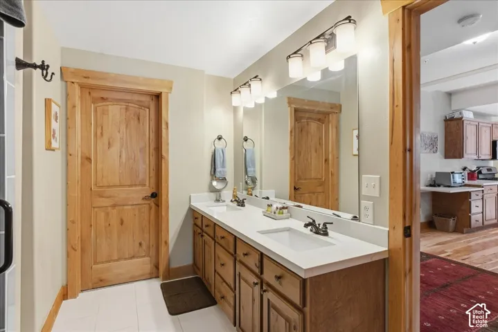 Dual vanity with white undermount sinks, white countertops, and wood-finish cabinetry