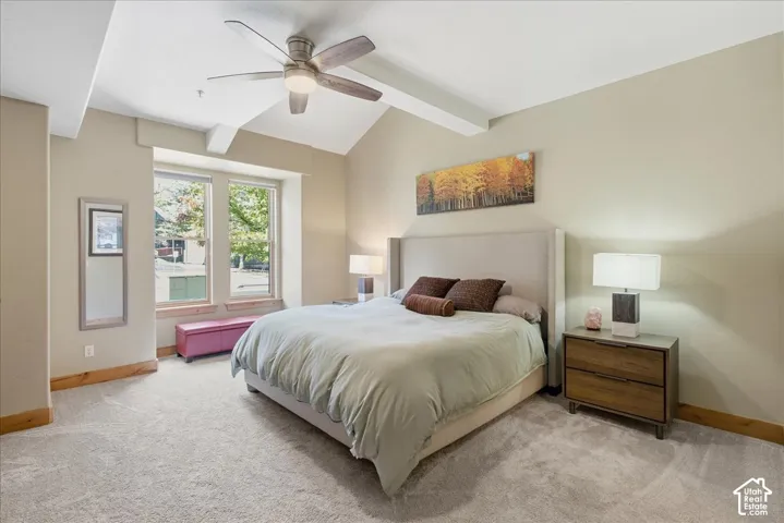 Vaulted ceiling with exposed beam, ceiling fan, and recessed lighting