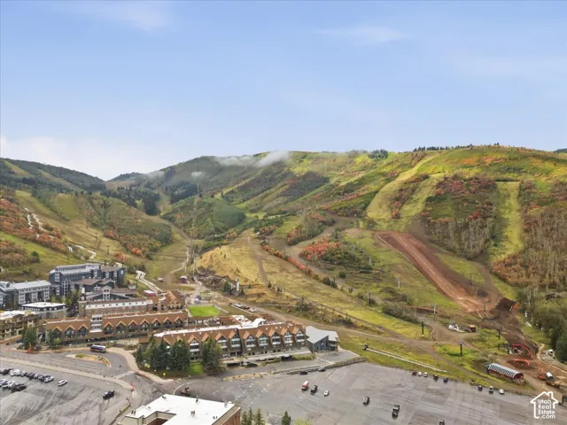Mountainous terrain with natural landscaping, visible ski runs, and multiple structures