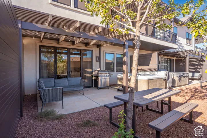 Outdoor patio with pergola, sliding glass doors, and a built-in spa
