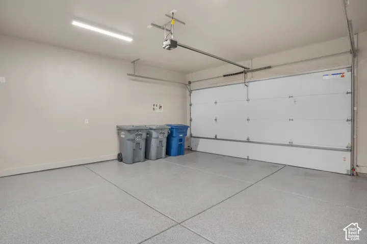 Garage featuring a finished floor coating, white overhead door, and automatic opener