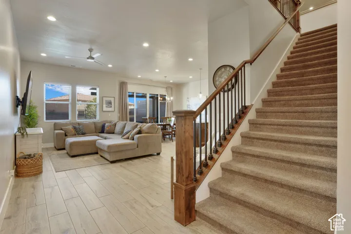 Open-concept living space featuring wood-finish flooring, recessed lighting, and a ceiling fan