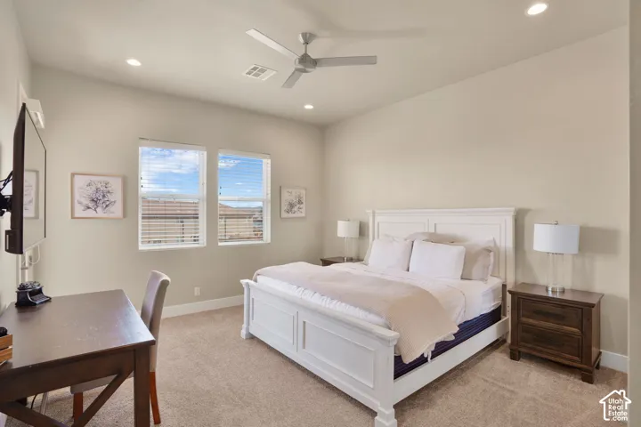 Carpeted room featuring a white paneled bed frame, dual windows with blinds, recessed lighting, and a ceiling fan