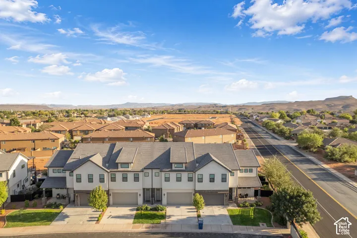 Terraced townhome residences with attached garages, paved driveways, and covered entryways
