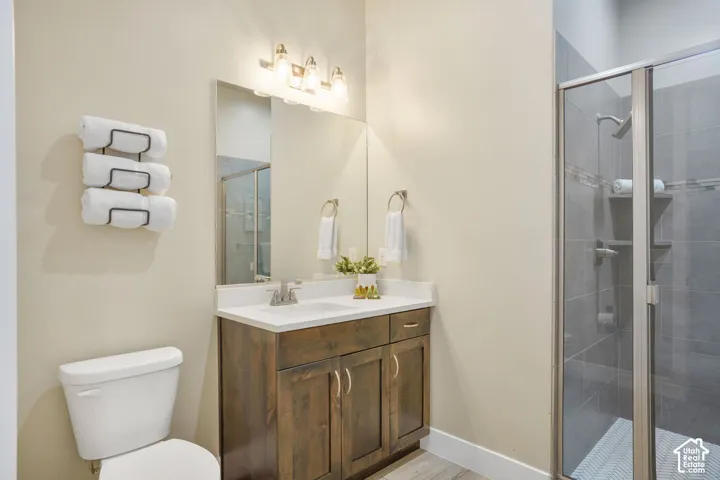 Bathroom featuring a single vanity with wood-finish cabinetry, a white countertop, and a rectangular sink