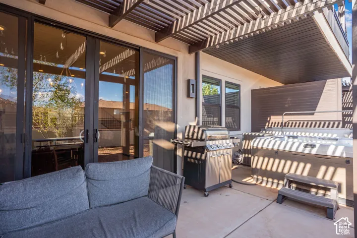 Patio with concrete flooring, pergola, sliding glass doors, and an integrated spa