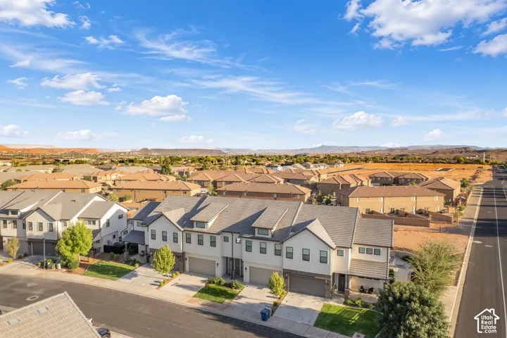 Townhome community featuring neutral-toned exteriors with attached garages and paved driveways