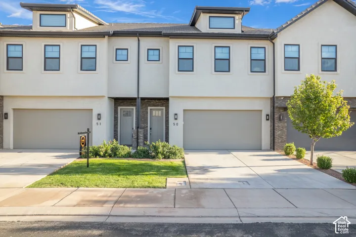 Stucco exterior with dormer windows and dark trim