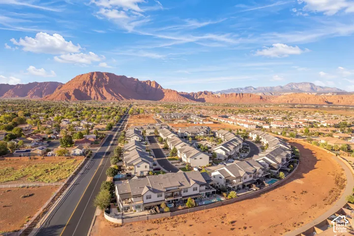 Modern residential development with a curved street layout, individual private pools, and contemporary building exteriors