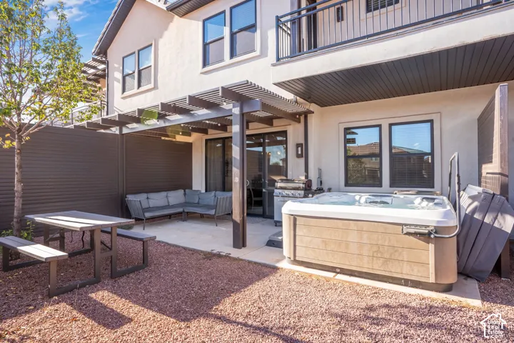 Private outdoor space featuring a hot tub, a pergola-covered patio, and gravel landscaping