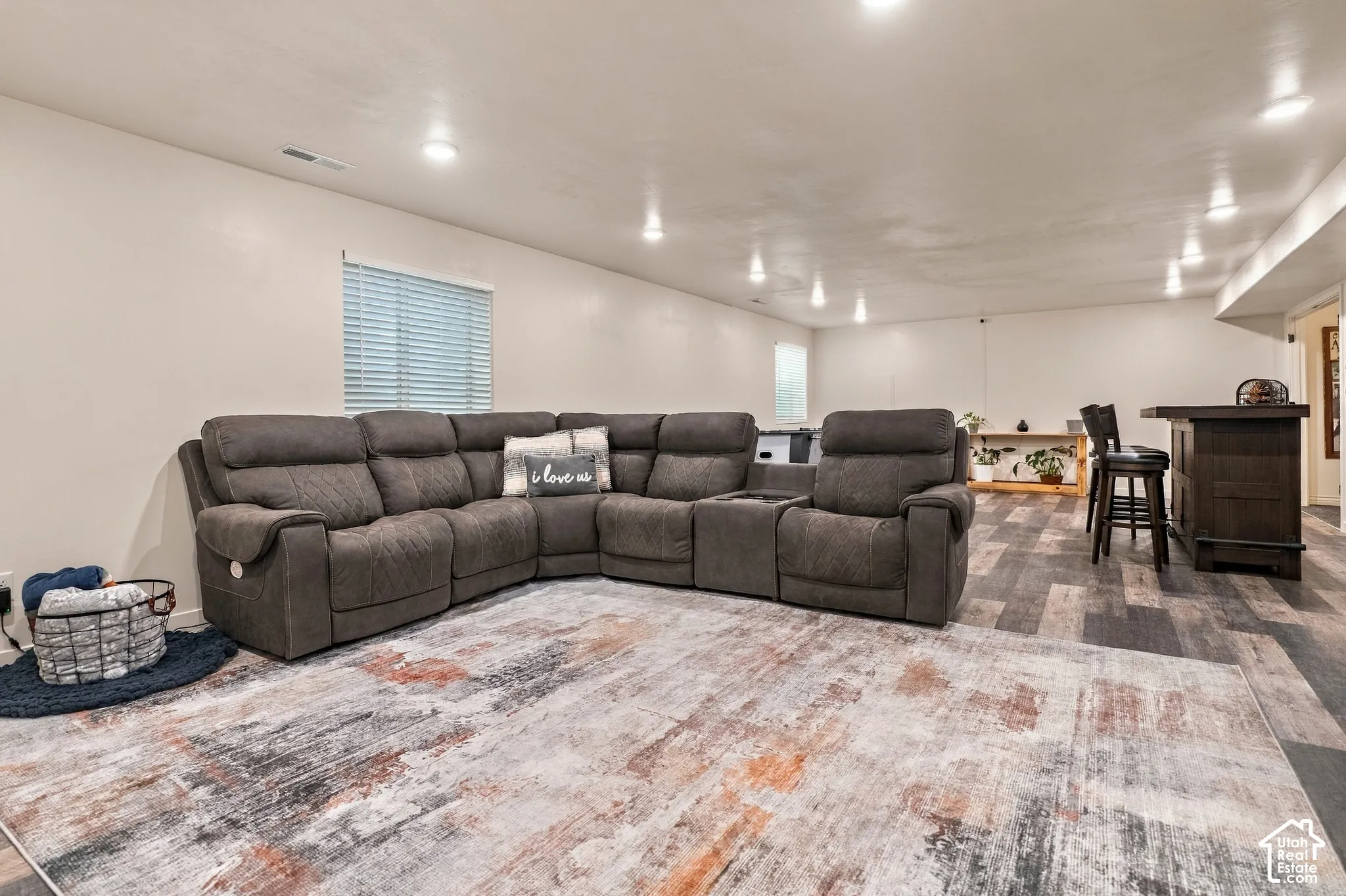 Recessed lighting, wood-look flooring, built-in bar with dark wood finish, and horizontal window blinds