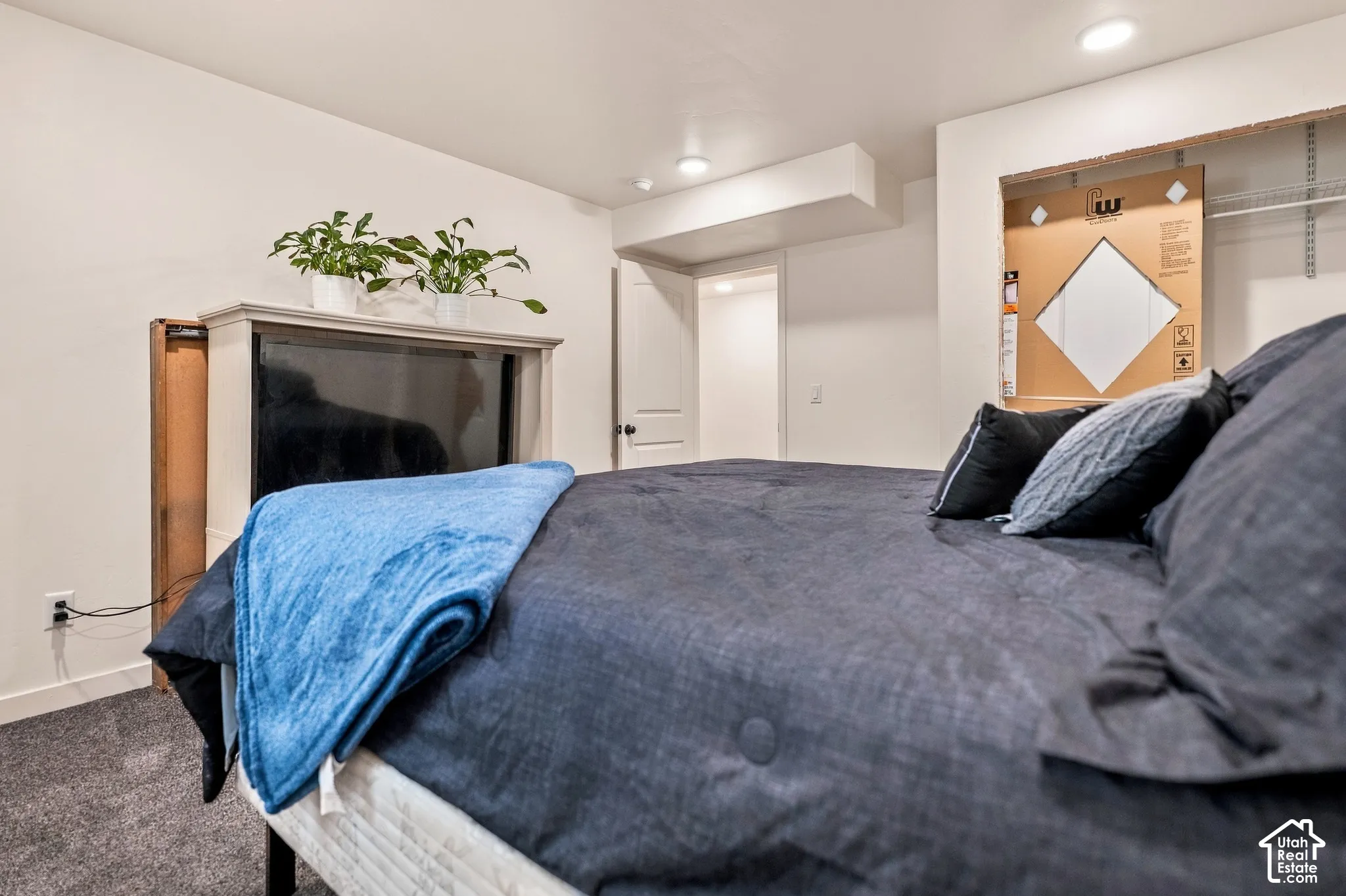 White interior walls, recessed ceiling lighting, and gray carpeted flooring