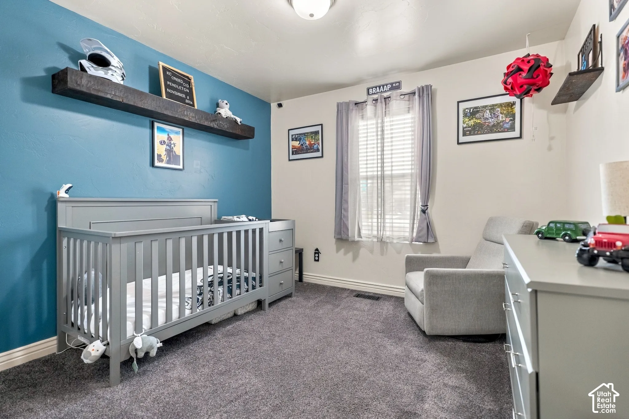 Textured carpet flooring, window with blinds, floating wall shelf, and two-tone wall paint