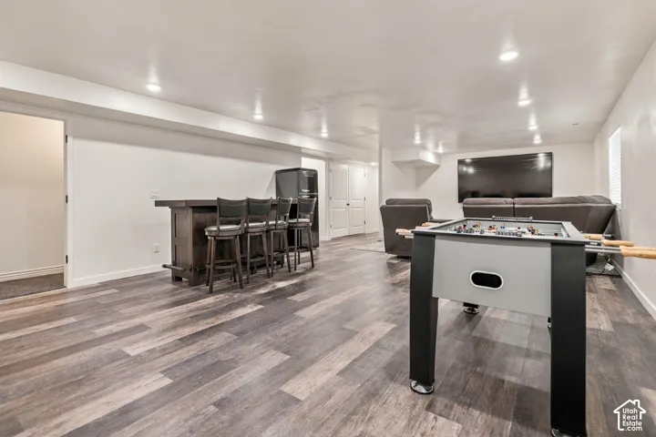 Spacious open concept room featuring wood-finish flooring and recessed lighting