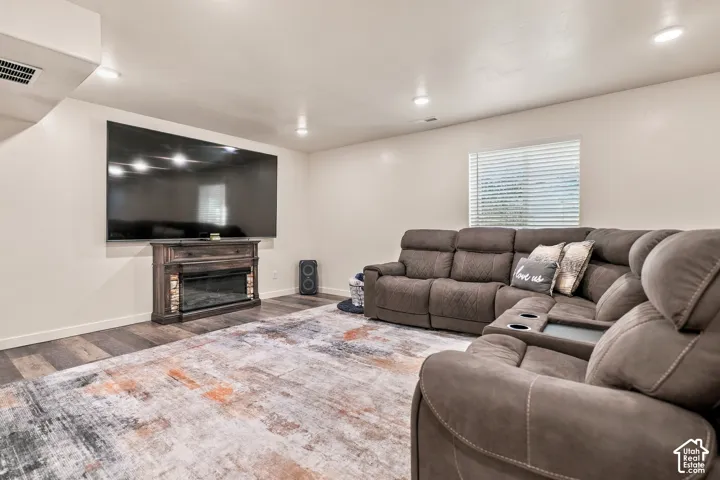 Recessed lighting illuminates the space with wood-finish flooring
