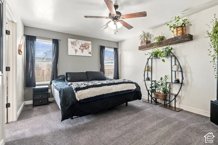 Carpeted bedroom featuring a ceiling fan, two windows with blinds, and recessed lighting