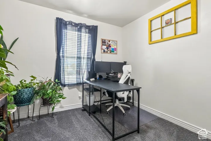 Room featuring a window with blinds, light-colored walls, and gray carpet flooring