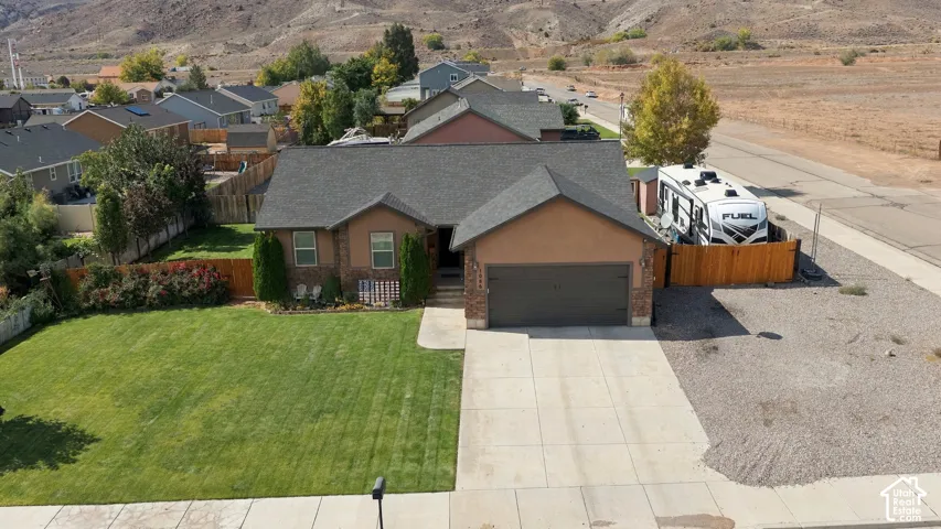 Ranch-style exterior with a hip roof, attached garage, and a concrete driveway