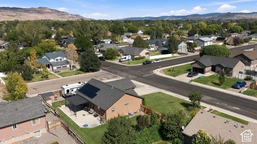 Modern home situated on a tree-lined residential street, featuring a contemporary architectural design with mixed exterior materials including brick and dark roofing