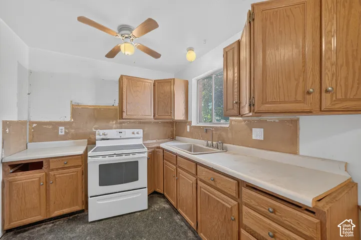 Kitchen featuring wood-finish cabinetry, white countertops, built-in sink, and a ceiling fan