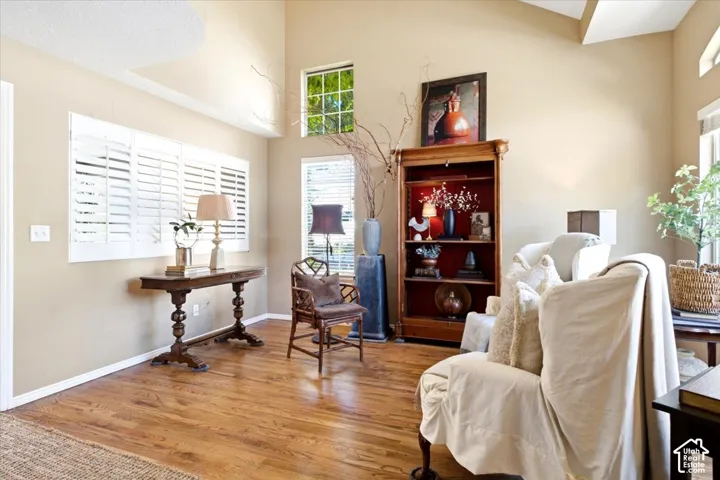 Vaulted ceilings, wood-finish flooring, white plantation shutters, built-in shelving, and transom windows