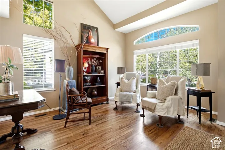 Vaulted ceiling, wood-finish flooring, clerestory window, large picture windows, and built-in shelving