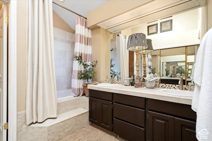 Dual vanity with integrated sinks, dark wood-finish cabinetry, and a full-width mirror
