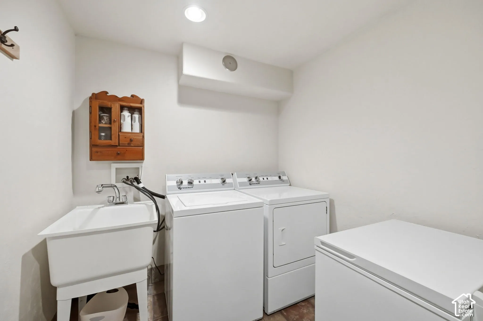 Laundry area featuring a utility sink with chrome faucet, wood-finish flooring, and recessed ceiling lighting