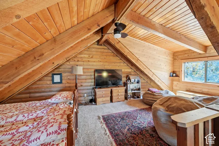 Wood-paneled ceilings with exposed beams, wood-finish walls, and a built-in window seat