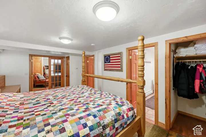 Wood-frame bed, wood-trim doorways, and a built-in closet with shelving and hanging rod