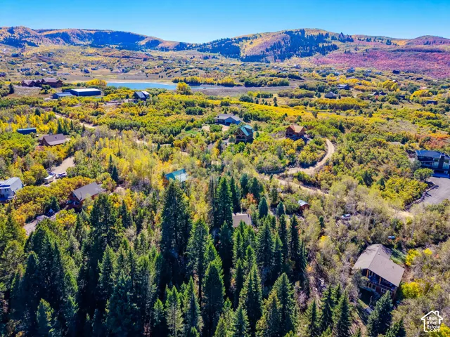 Surrounded by mature trees with distant mountains and a body of water