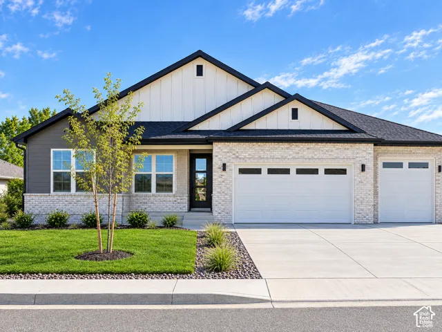 Modern exterior featuring light brick, dark gray siding, white vertical siding, and a black shingle roof