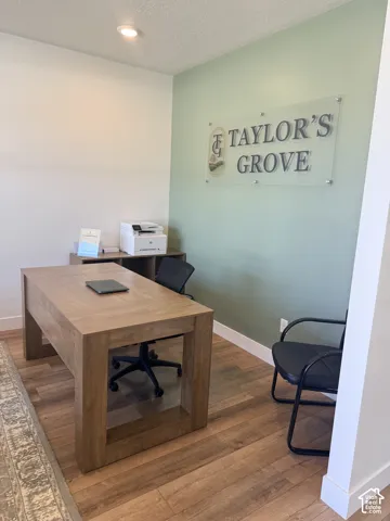 Recessed ceiling lighting, wood-finish flooring, two-tone wall paint, built-in shelving, and a wood-finish desk