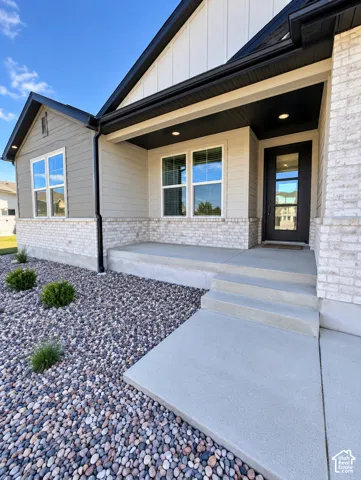 Contemporary architecture featuring a light brick facade, contrasting dark trim, and a covered entryway
