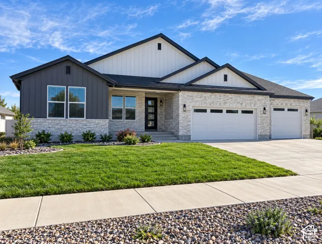 Exterior featuring stone accents, vertical siding, a multi-car garage, and a concrete driveway