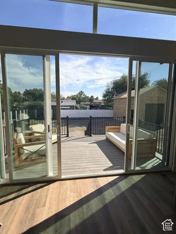 Full-height sliding glass doors opening to a spacious deck with dark railing and composite decking
