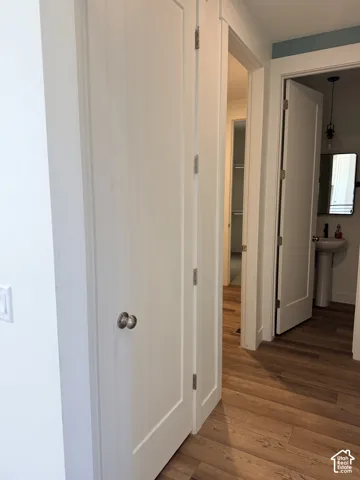 Wood-finish flooring with white trim and solid core doors
