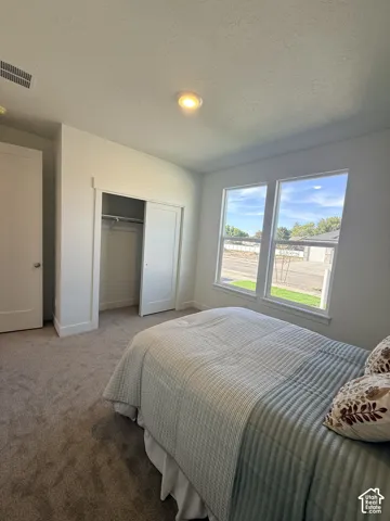 Recessed ceiling light, neutral wall paint, white trim, sliding closet doors, and carpet flooring
