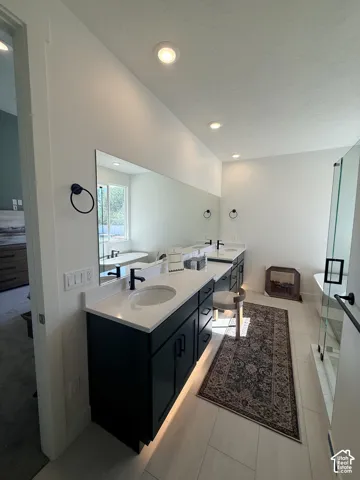 Double vanity with dark cabinetry, white countertops, and integrated sinks