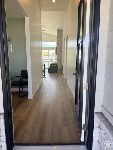 Wood-finish flooring throughout, featuring a vaulted ceiling with recessed lighting