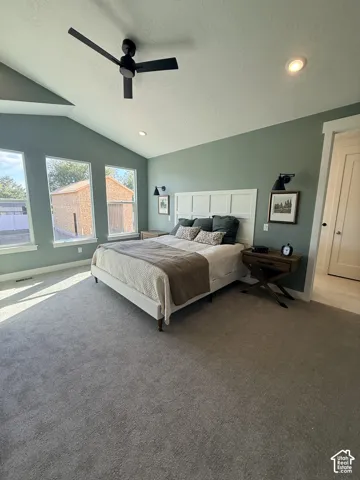 Vaulted ceiling with a black ceiling fan, recessed lighting, accent wall, multiple windows, and carpet flooring