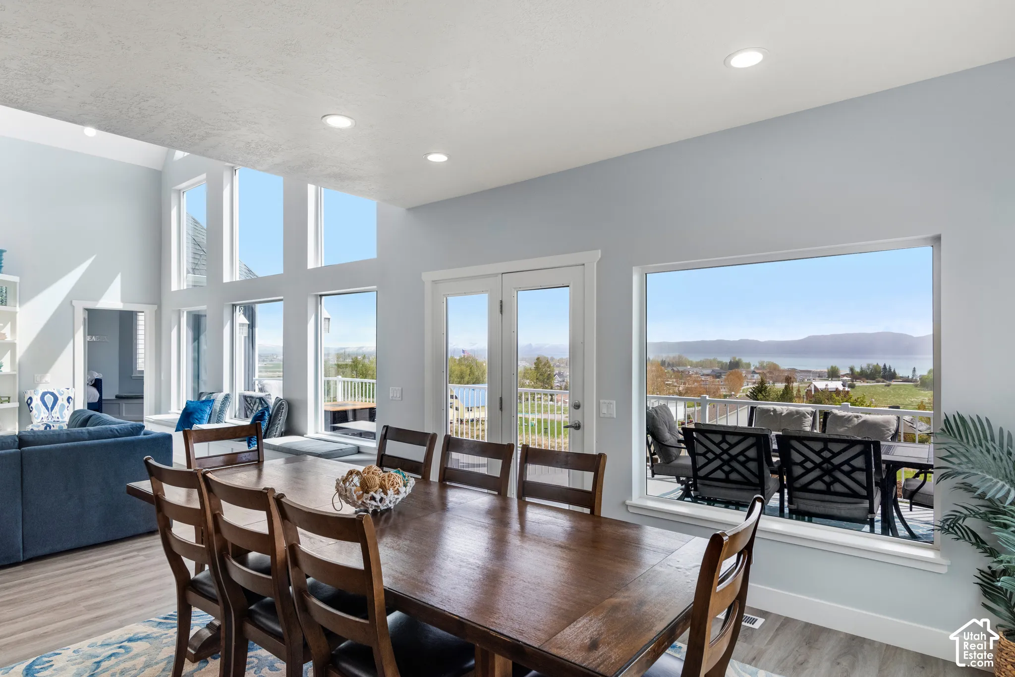 Wood-finish flooring throughout, with a tall wall of windows providing a bright interior