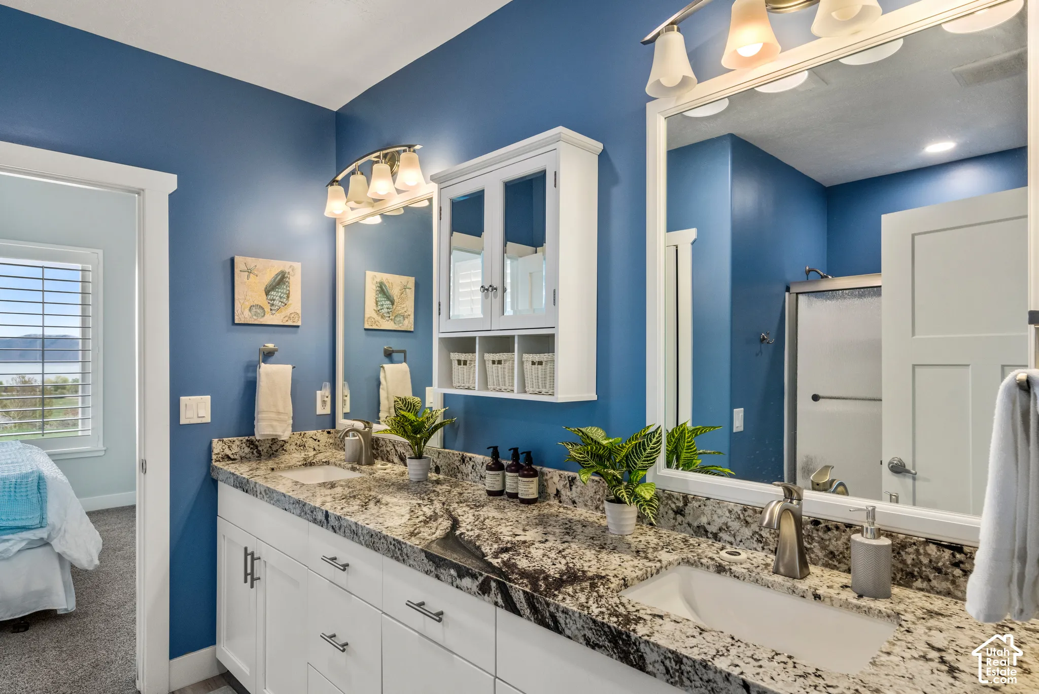 Dual vanity with undermount sinks, granite-finish countertops, and white shaker-style cabinetry