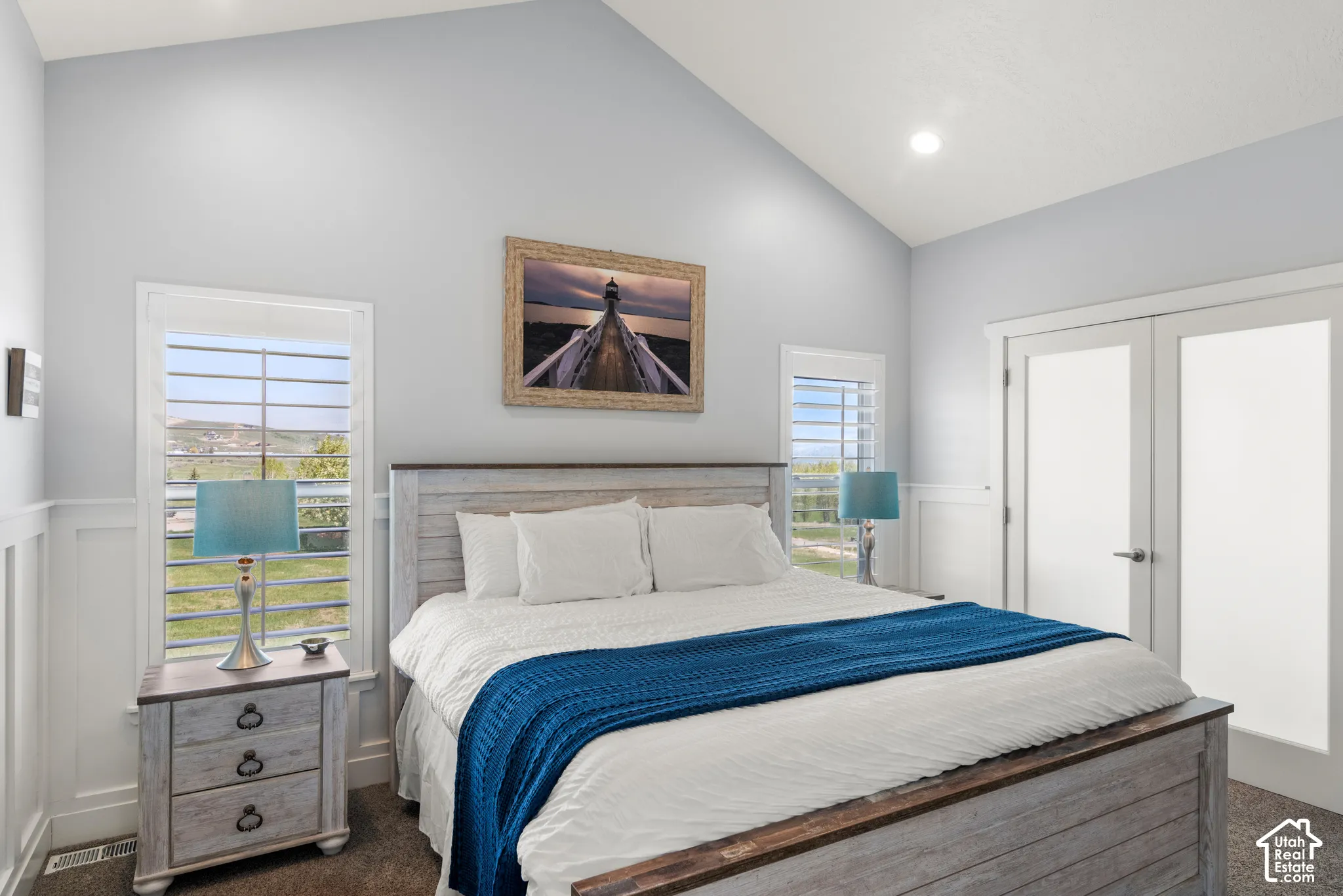 Vaulted ceiling, recessed lighting, white wainscoting, double-paned windows, and double French doors with frosted glass