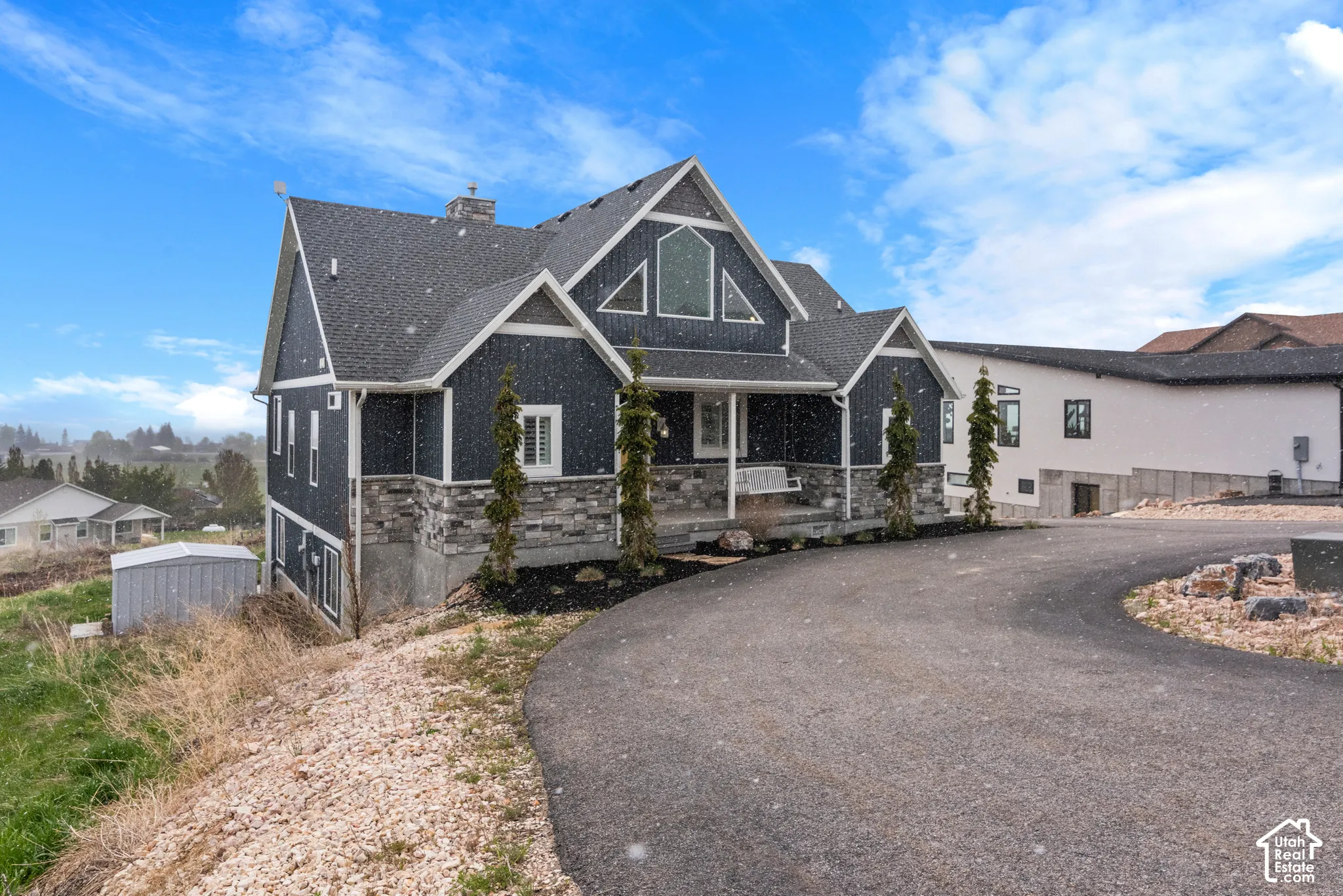 Contemporary-style exterior with dark siding and stone accents